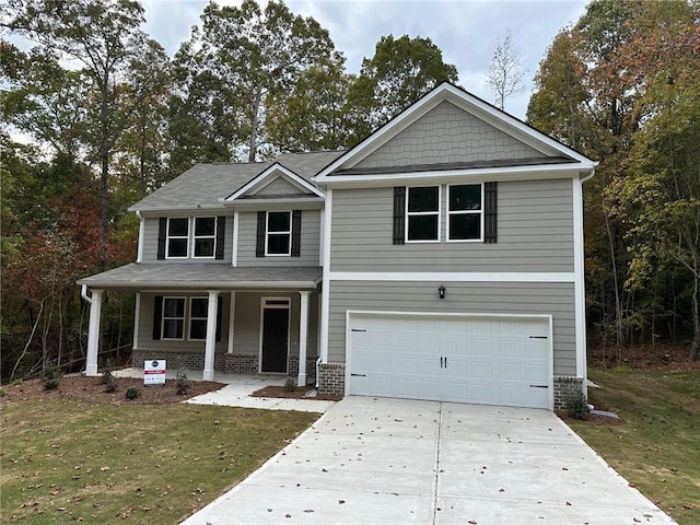 craftsman house with a front lawn, covered porch, an attached garage, and concrete driveway