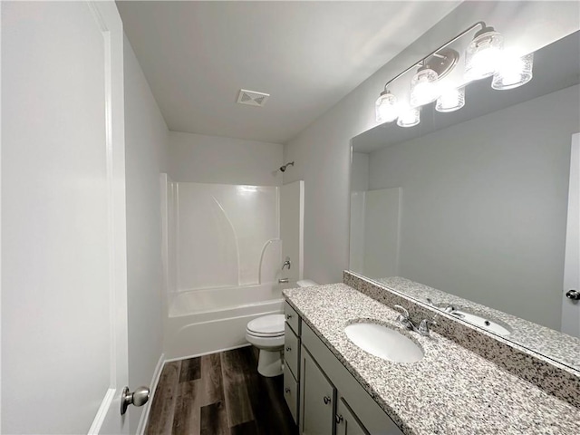 full bath with bathing tub / shower combination, visible vents, toilet, vanity, and wood finished floors