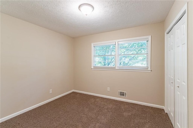 unfurnished bedroom with a closet, a textured ceiling, and carpet flooring