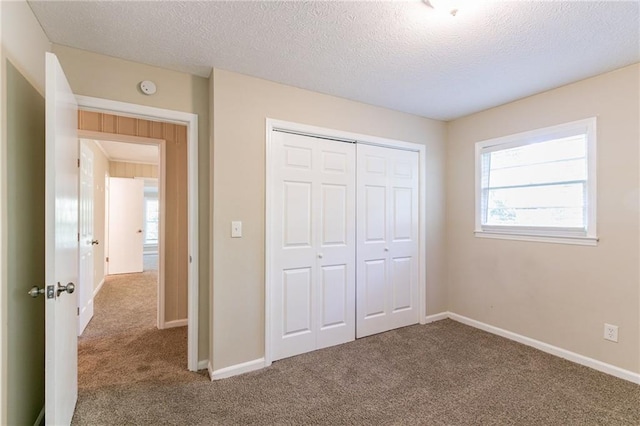 unfurnished bedroom with a closet, a textured ceiling, and carpet