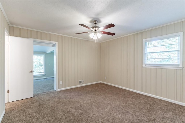 carpeted empty room with ornamental molding and ceiling fan