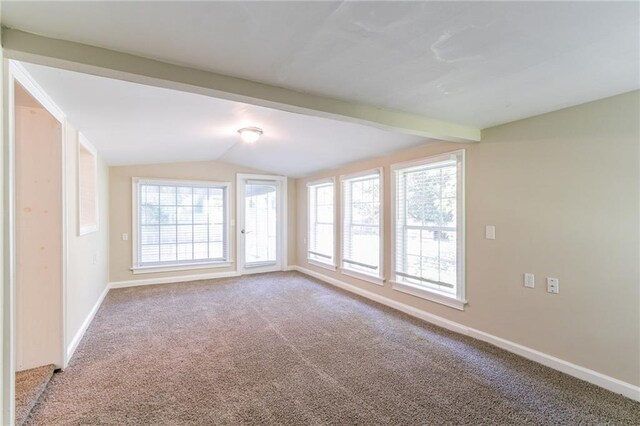 carpeted spare room with lofted ceiling