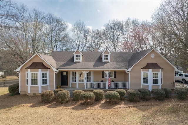 cape cod-style house with a porch and a chimney