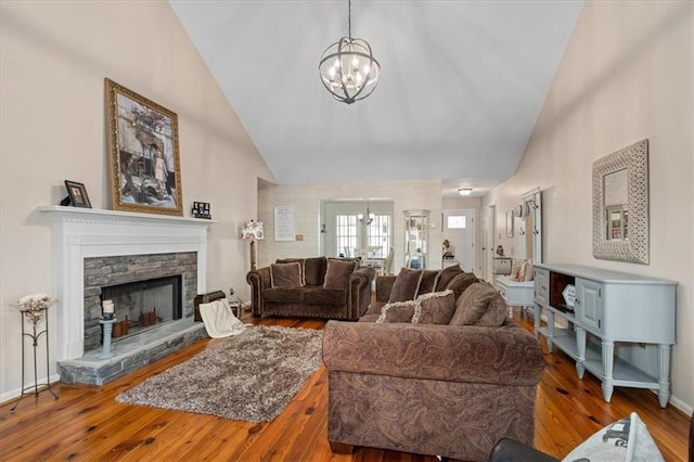 living area with a chandelier, high vaulted ceiling, baseboards, and wood-type flooring