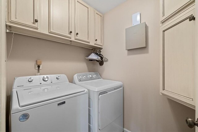 washroom featuring cabinet space and washing machine and clothes dryer