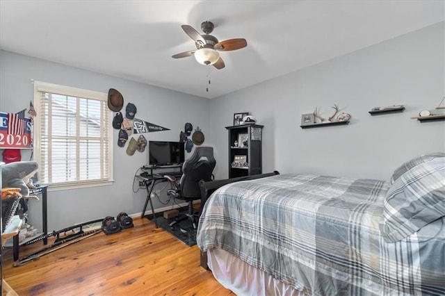 bedroom with light wood-style floors, baseboards, and ceiling fan