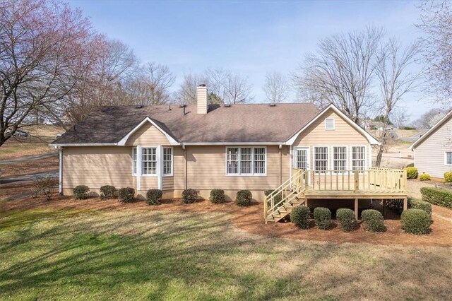 back of property featuring a deck, a chimney, stairs, and a yard