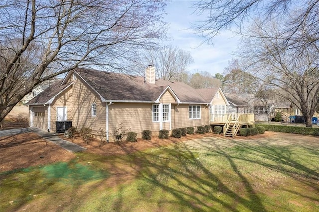 exterior space with a lawn, a chimney, a garage, a deck, and crawl space