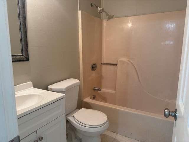 full bathroom featuring toilet, washtub / shower combination, and vanity