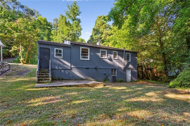 rear view of property featuring cooling unit and a yard