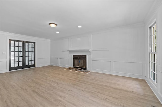4166 Riverhill Ct NE, Roswell, GA 30075 - unfurnished living room with a decorative wall, ornamental molding, french doors, light wood finished floors, and a fireplace with raised hearth
