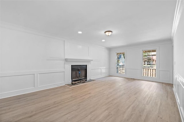 4166 Riverhill Ct NE, Roswell, GA 30075 - unfurnished living room featuring a decorative wall, ornamental molding, a fireplace with raised hearth, light wood-style floors, and recessed lighting