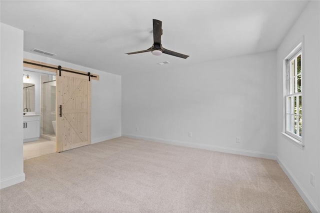 4166 Riverhill Ct NE, Roswell, GA 30075 - unfurnished bedroom featuring carpet floors, a barn door, baseboards, and a ceiling fan