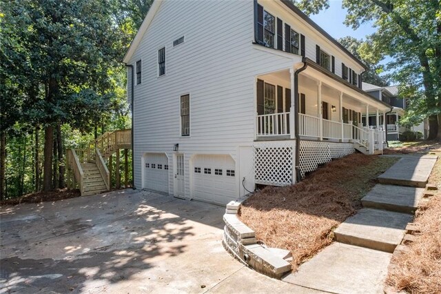 4166 Riverhill Ct NE, Roswell, GA 30075 - view of side of property with stairs, covered porch, an attached garage, and driveway