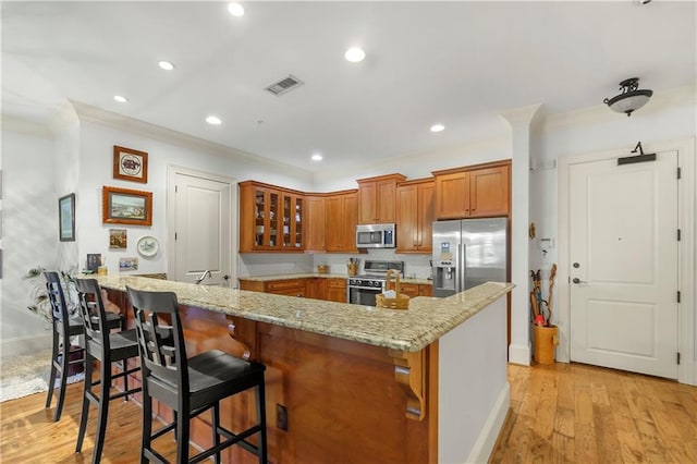 351 NE Washington Ave NE Unit 307, Marietta, GA 30060 - kitchen with appliances with stainless steel finishes, brown cabinetry, light stone countertops, ornamental molding, and baseboards