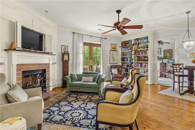 351 NE Washington Ave NE Unit 307, Marietta, GA 30060 - living room featuring ceiling fan, light wood-style flooring, a tiled fireplace, and ornamental molding
