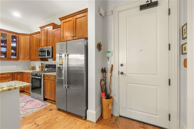 351 NE Washington Ave NE Unit 307, Marietta, GA 30060 - kitchen with appliances with stainless steel finishes, brown cabinets, tasteful backsplash, light wood-style floors, and recessed lighting