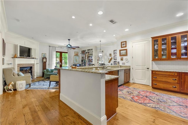 351 NE Washington Ave NE Unit 307, Marietta, GA 30060 - kitchen featuring a peninsula, stainless steel dishwasher, ornamental molding, brown cabinets, and open floor plan