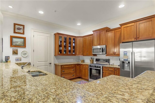 351 NE Washington Ave NE Unit 307, Marietta, GA 30060 - kitchen with stainless steel appliances, a sink, light stone countertops, glass insert cabinets, and ornamental molding
