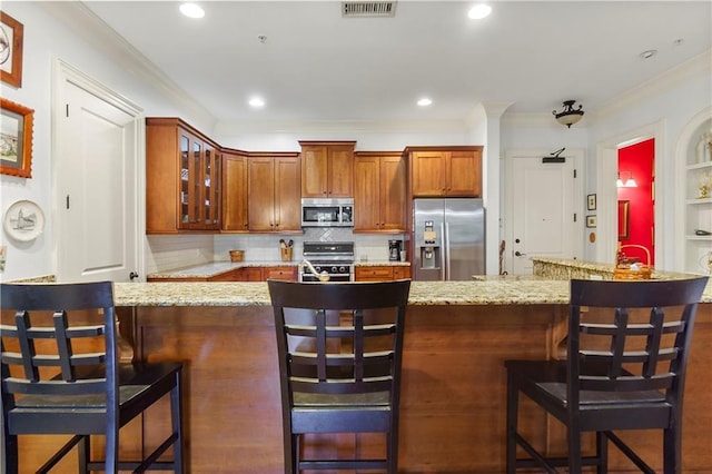 351 NE Washington Ave NE Unit 307, Marietta, GA 30060 - kitchen with appliances with stainless steel finishes, a kitchen breakfast bar, ornamental molding, glass insert cabinets, and tasteful backsplash