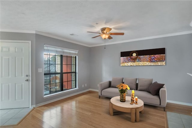 living room with hardwood / wood-style floors, ornamental molding, and ceiling fan