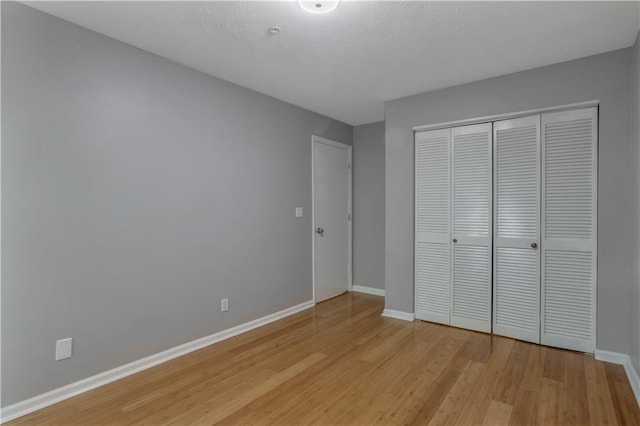 unfurnished bedroom with a closet and light hardwood / wood-style flooring