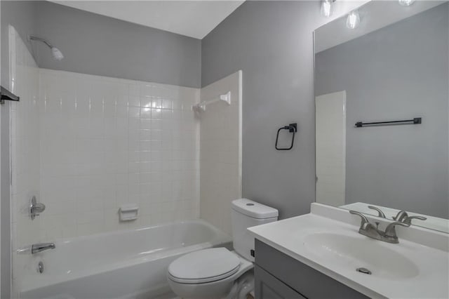 full bathroom featuring tiled shower / bath combo, vanity, and toilet