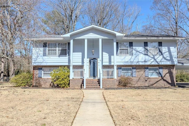 bi-level home with covered porch and brick siding