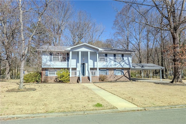 split foyer home featuring a carport, brick siding, and a front yard