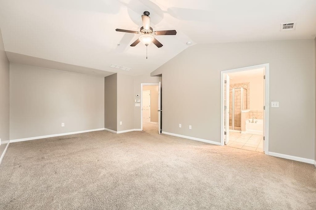 unfurnished bedroom featuring ceiling fan, lofted ceiling, light carpet, and connected bathroom