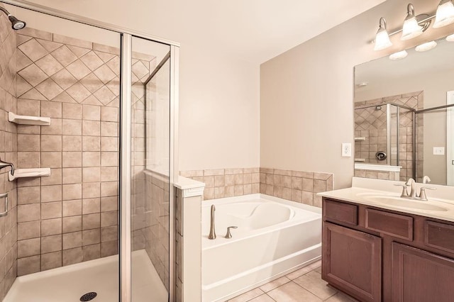 bathroom with tile patterned flooring, vanity, and shower with separate bathtub