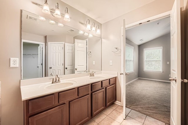 bathroom featuring tile patterned flooring, vanity, and lofted ceiling