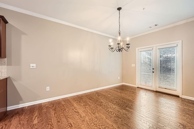 unfurnished dining area with crown molding, french doors, a notable chandelier, and hardwood / wood-style flooring