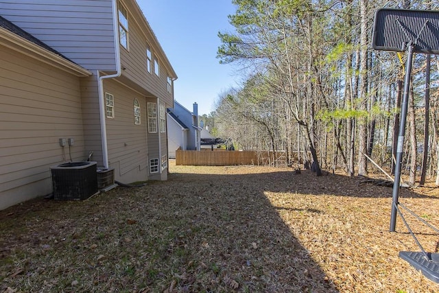 view of yard featuring central AC unit and fence