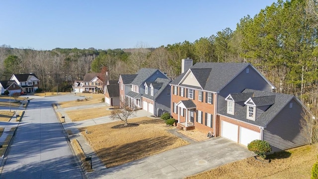 aerial view featuring a forest view and a residential view