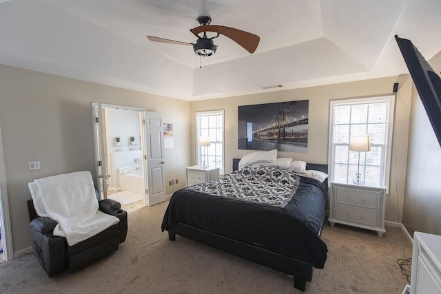 bedroom featuring visible vents, multiple windows, light colored carpet, and a raised ceiling