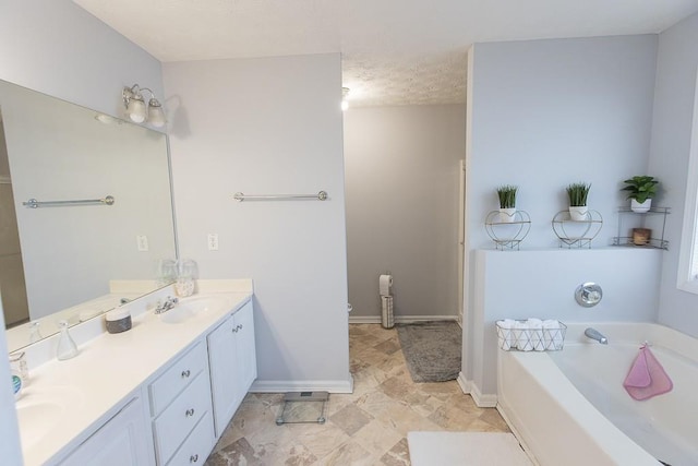 full bathroom with a garden tub, double vanity, baseboards, and a sink