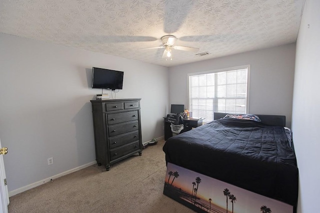 bedroom with visible vents, light carpet, a textured ceiling, and baseboards