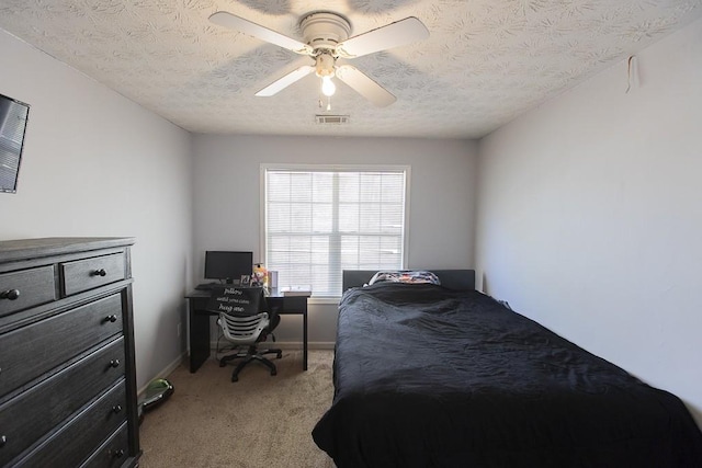 carpeted bedroom with visible vents, baseboards, a textured ceiling, and ceiling fan