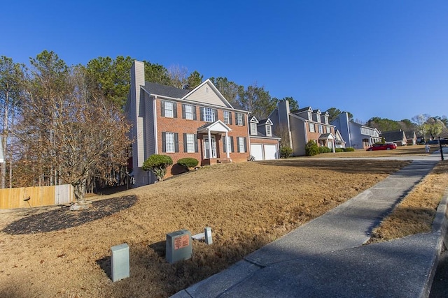 view of front of home featuring a garage, brick siding, a residential view, and a chimney