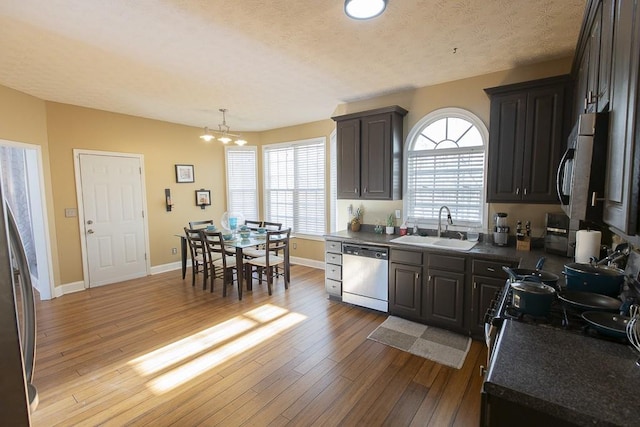 kitchen with a sink, dark countertops, and appliances with stainless steel finishes