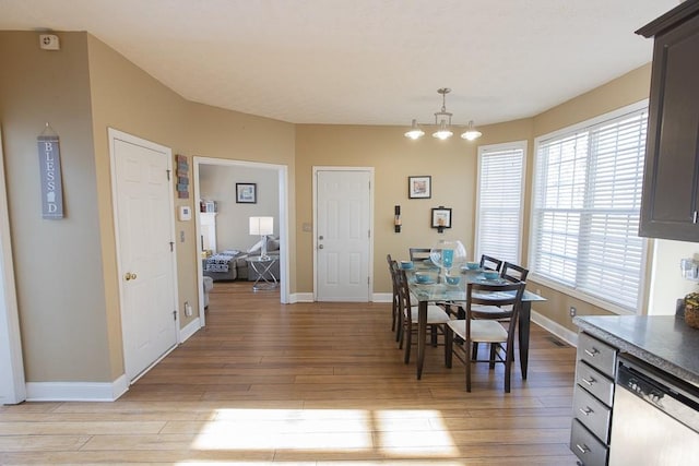 dining area featuring baseboards and light wood-style flooring