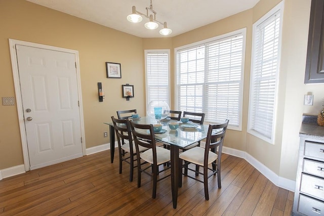 dining room featuring an inviting chandelier, wood finished floors, and baseboards