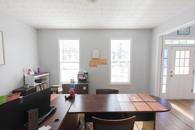 office area featuring a wealth of natural light, a textured ceiling, and wood finished floors