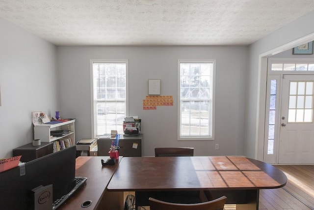 dining area featuring a textured ceiling and wood finished floors