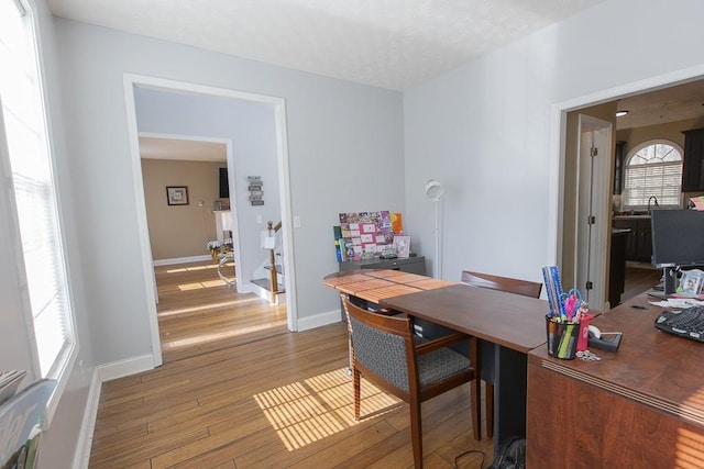 office area with wood finished floors, baseboards, and a textured ceiling