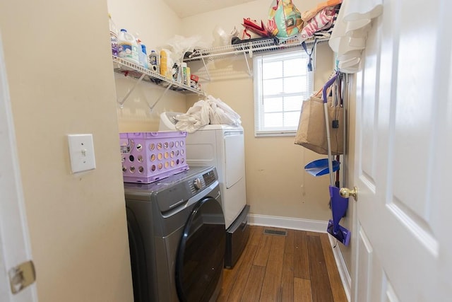 laundry room with baseboards, visible vents, laundry area, separate washer and dryer, and hardwood / wood-style flooring