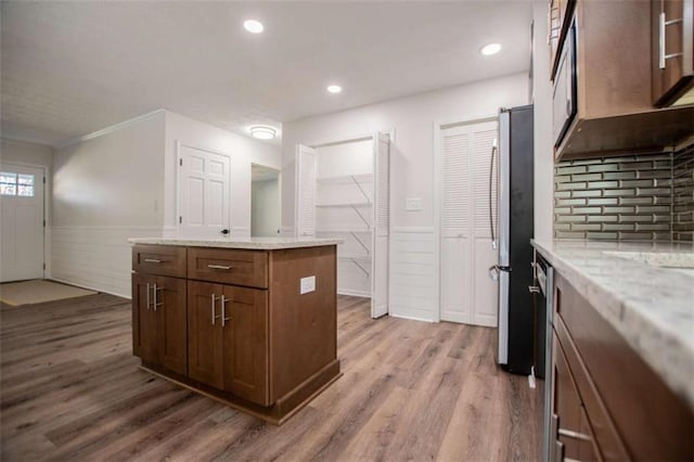 280 Hitchcock Rd, Dallas, GA 30157 - kitchen with a wainscoted wall, a center island, freestanding refrigerator, wood finished floors, and light stone countertops