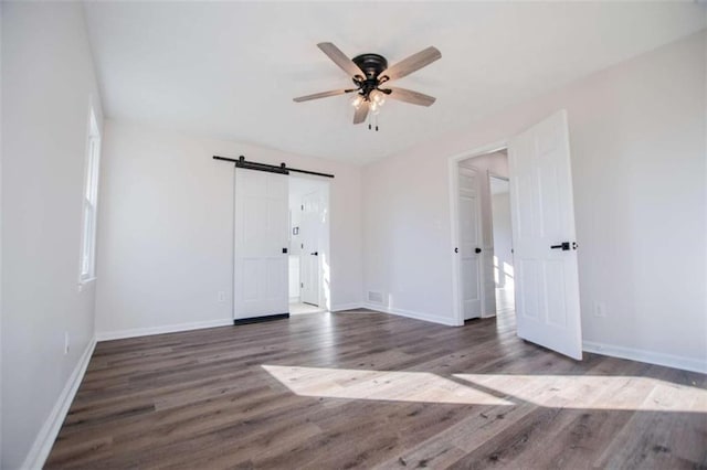 280 Hitchcock Rd, Dallas, GA 30157 - unfurnished bedroom featuring wood finished floors, a barn door, baseboards, and a ceiling fan