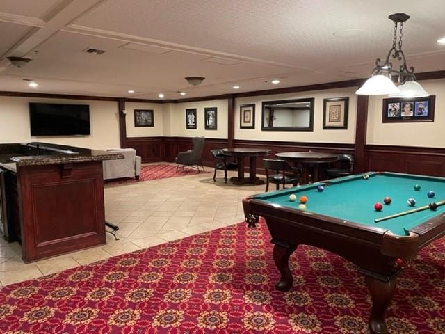 recreation room with crown molding and light tile patterned floors